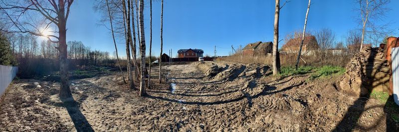 Panoramic shot of railroad tracks on field against sky