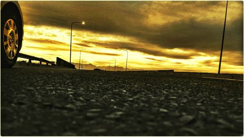 Surface level of road against cloudy sky