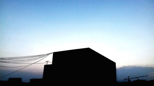 Low angle view of silhouette buildings against clear sky