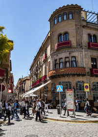 People on street in city against clear sky