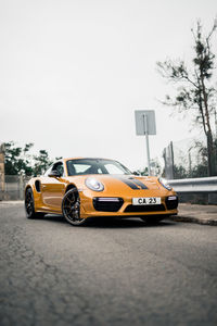 Yellow car on road against sky