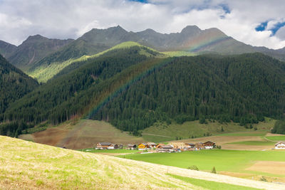 Scenic view of green landscape and mountains against sky