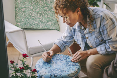 Mature woman drawing art on table