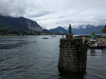 Scenic view of lake and mountains against cloudy sky