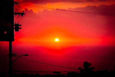 Silhouette of power lines against dramatic sky