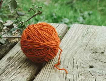 High angle view of orange wool ball on wooden table