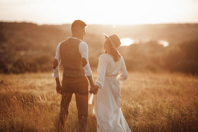 Rear view of couple standing on land