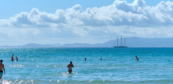 People on beach against sky