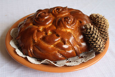 Close-up of brown homemade cake with pine cones in plate on table