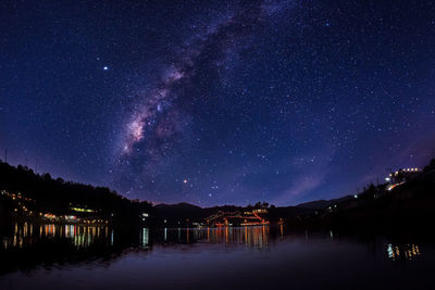 Scenic view of lake against sky at night