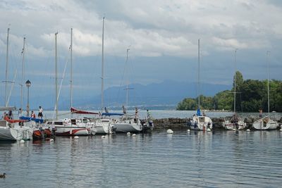 Boats moored in lake against sky