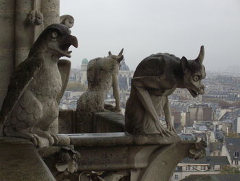 Statue by historic building against sky