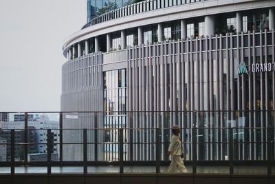 Man walking by modern building in city