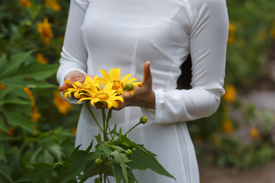 Close-up of woman with yellow flowers