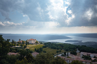 High angle view of townscape by lake against sky