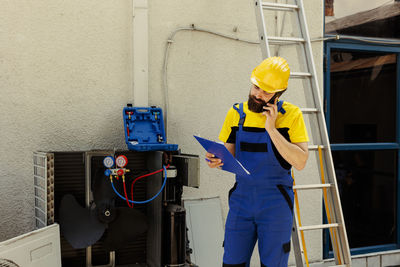 Low angle view of man standing against wall