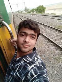 Portrait of young man against train