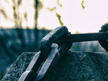 Close-up of railing by pier against sky