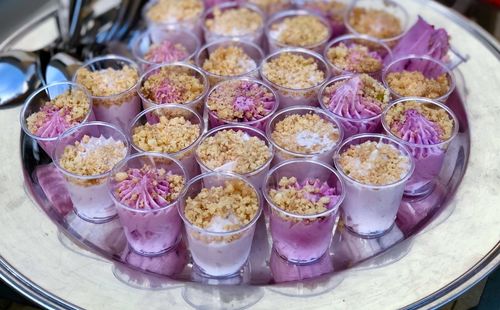 Sweets in cream of colored black cherry inside small glasses to eat with teaspoons