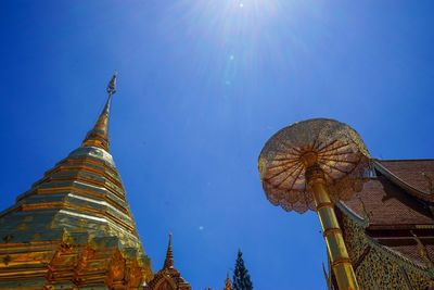 Low angle view of temple against building on sunny day