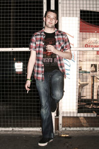 Portrait of young man standing against wall