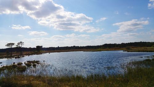 Scenic view of lake against cloudy sky