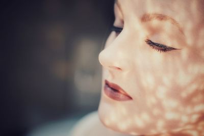 Close-up portrait of young woman with eyes closed