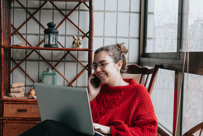 Portrait of smiling young woman using mobile phone