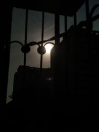 Close-up of silhouette window against sunset sky