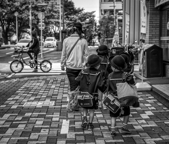 street, building exterior, city, land vehicle, transportation, bicycle, mode of transport, men, city life, architecture, walking, built structure, car, lifestyles, person, city street, full length, rear view, leisure activity