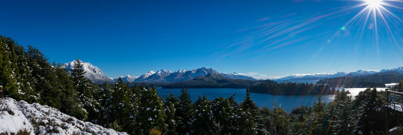 Scenic view of lake and mountains against blue sky