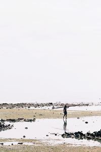 Man working in sea against clear sky