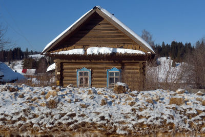 Built structure on snow covered field against clear sky