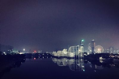 Illuminated city against sky at night