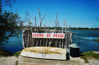 Information sign on beach against clear blue sky