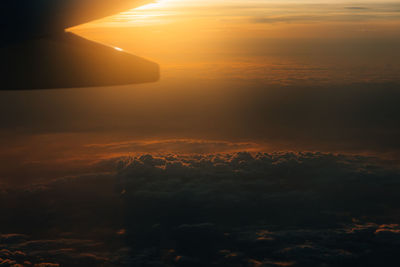 A sunset view on a plane heading to southern europe late in the evening above the clouds