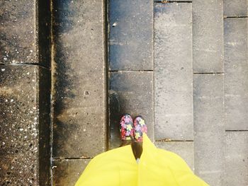 Rear view of woman standing against yellow wall