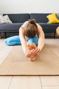 High angle view of woman lying down on wooden floor