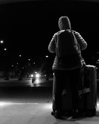 Rear view of a man standing at night
