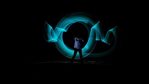 Man with light painting in dark
