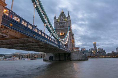 Illuminated bridge over river in city