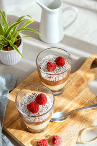 Three-layer mousse dessert made of chocolate and vanilla, decorated with fresh raspberries 