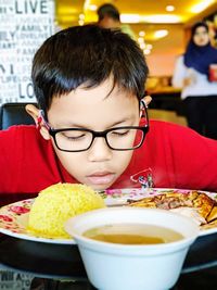 Boy with food on table in restaurant