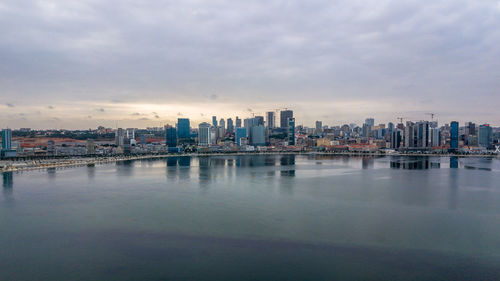 Cityscape by sea against sky