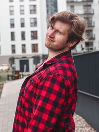 Side view of young man standing in city