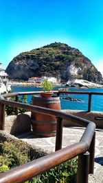 Scenic view of sea and mountains against clear blue sky