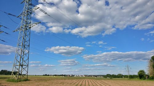 Electricity pylon on field against sky