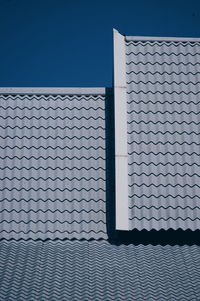 Roof tiles of house against clear sky