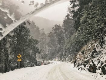 Road amidst trees and mountains against sky