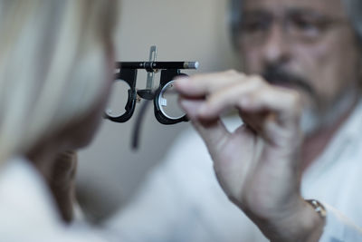 Optometrist adjusting test frame for patient